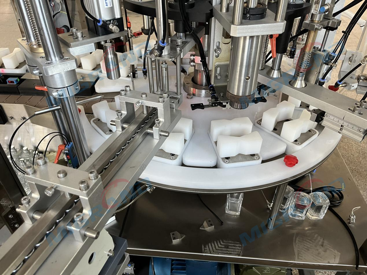 Parf&uuml;m doldurma makinesinin kapak kilitleme istasyonu